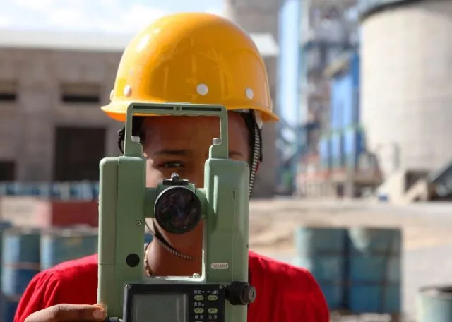 Young female on a construction site operating equipment