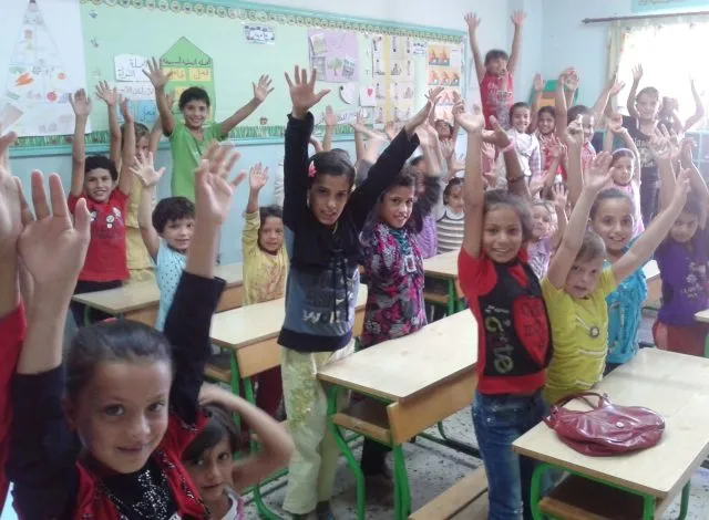 A classroom of young children cheering