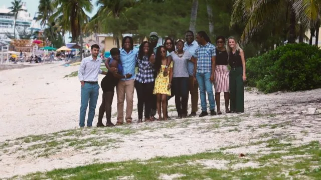 A group of diverse people huddled together on the beach