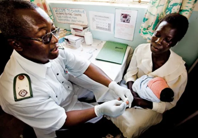Doctor testing a baby for HIV whilst being held my a woman
