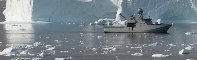 Military ship floating in an ice field