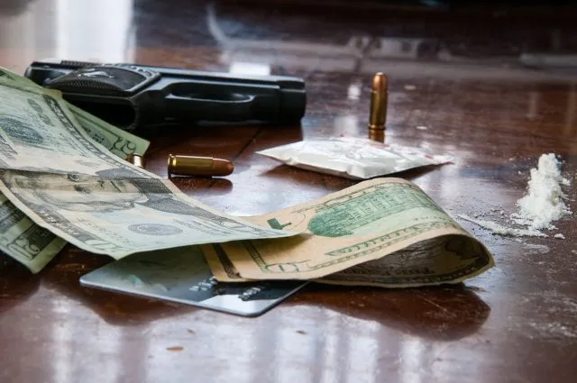 A desk full of drugs, money and guns