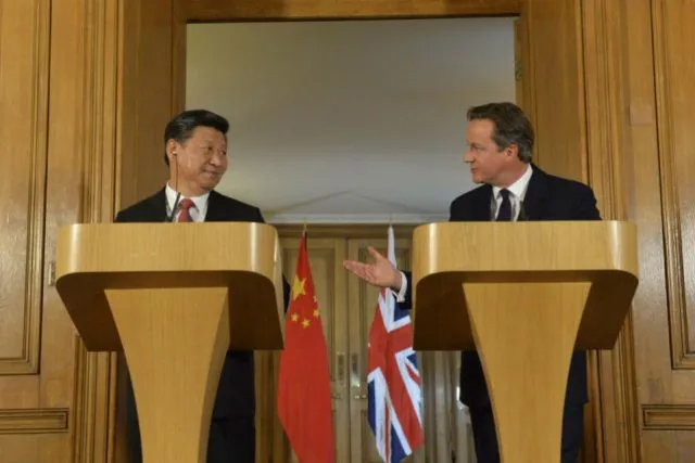 David Cameron and Xi Jinping stand together at lecterns.