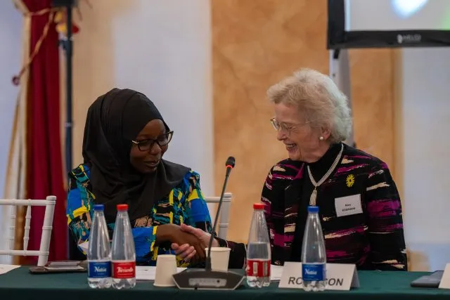 Former President of Ireland and Chair of The Elders Mary Robinson and Faith for our Planet Youth Ambassador Fariah Lalaikiapan shake hands at the conference table