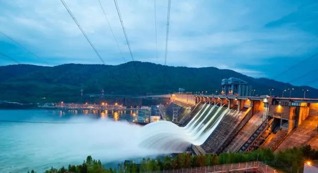 Water flows through a dam into a lake