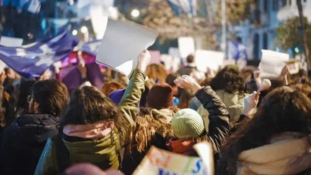 Protestors on a night march hold up placards